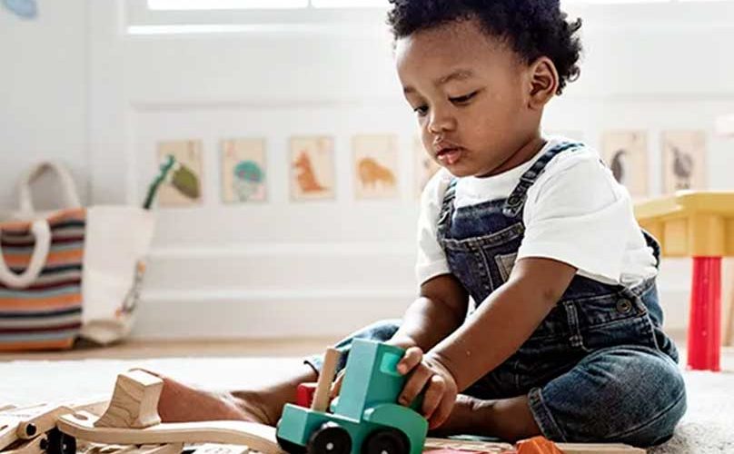 Enfant de trois ans explorant des objets Montessori